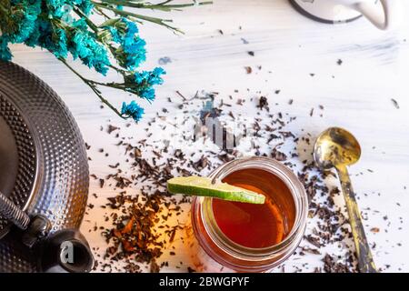 Schwarzer Tee auf Vintage-Hintergrund, für einen heißen Tag, Bio mit Flasche Stockfoto