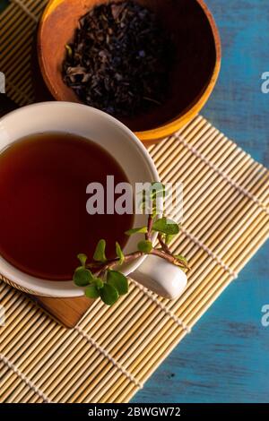 Schwarzer Tee auf Vintage-Hintergrund, für einen heißen Tag, Bio mit Flasche Stockfoto