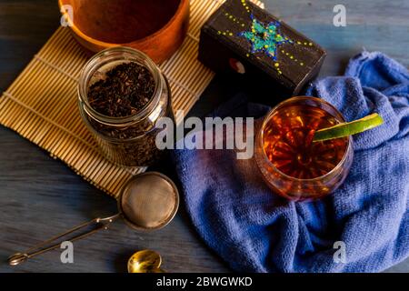 Schwarzer Tee auf Vintage-Hintergrund, für einen heißen Tag, Bio mit Flasche Stockfoto