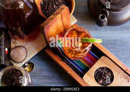 Schwarzer Tee auf Vintage-Hintergrund, für einen heißen Tag, Bio mit Flasche Stockfoto