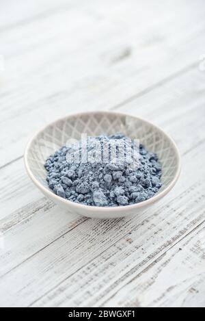 Blauer Matcha-Tee-Pulver in Teller auf weißem Holzhintergrund Nahaufnahme Stockfoto