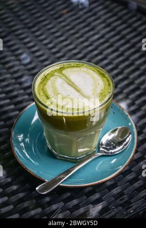 Matcha Latte aus Glas auf dem Tisch in Café Nahaufnahme Stockfoto