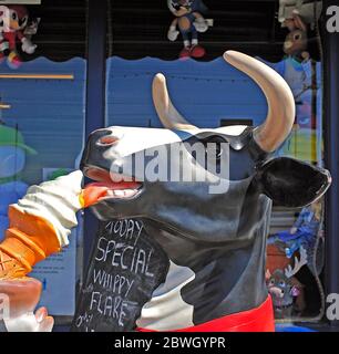 Kunststoff schwarz-weiße Kuh essen Eis vor dem Geschäft in Blackpool Stockfoto