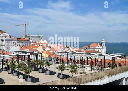 LISSABON, PORTUGAL - 2. JULI 2019: Blick vom Miradouro das Portas do Sol auf den Stadtteil Alfama und den Fluss Tejo in Lissabon, Portugal Stockfoto