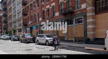 New York, NY - 1. Juni 2020: Plünderungen und Zerstörungen folgen friedlichen Protesten in der Sonntagabend-Nacht in SoHo-Gegend von Manhattan. Reihe von Geschäften mit vernagelten Fenstern Stockfoto