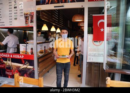 Ankara, Türkei. Juni 2020. Ein Kellner serviert am 1. Juni 2020 in einem Restaurant in Ankara, Türkei, eine Mahlzeit. Die Türkei hat am Montag einen wichtigen Schritt in Richtung Normalisierung unternommen und es den Restaurants, Cafés und vielen Geschäften ermöglicht, nach mehr als zwei Monaten COVID-19-Sperrbeschränkungen wieder zu öffnen, aber die Gesundheitsexperten fordern Wachsamkeit. Kredit: Mustafa Kaya/Xinhua/Alamy Live News Stockfoto