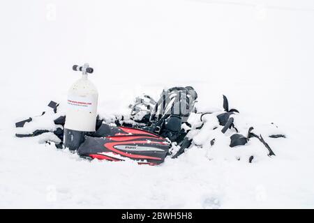 Tauchausrüstung unter dem Schnee, der in der Nacht gefallen ist, nur im Frühling, wenn der harte Winter langsam nachlässt, sind die eiskalten Gewässer geeignet Stockfoto