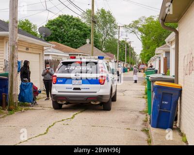 Oak Park, Illinois. Juni 2020. Ein Polizei-SUV durchfährt eine Gasse, in der sowohl anti-weiße als auch anti-schwarze Graffiti auf Garagen gesprüht wurden. Offensichtlich wussten die Purpetratoren, wer auf jedem markierten Grundstück lebte, da sowohl Anti-Weiß- als auch Anti-Schwarz-Graffiti auf ausgewählten Immobilien verwendet wurden und mit der Rasse der Hausbesitzer variierten. Stockfoto