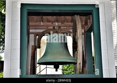 Die alte Glocke sitzt vor der Presbyterianischen Kirche von Brandon. Stockfoto