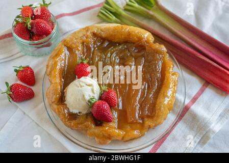 Rhabarber umgedrehten Kuchen mit Erdbeeren und Eis Stockfoto