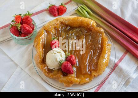 Rhabarber umgedrehten Kuchen mit Erdbeeren und Eis Stockfoto