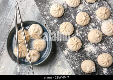 Gekochte und rohe Knödel auf dem Tisch Stockfoto