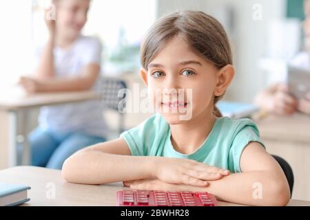 Kleines Mädchen tun mathematische Aufgabe im Klassenzimmer Stockfoto