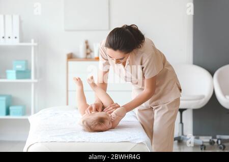 Masseur arbeitet mit niedlichen Baby in medizinischen Zentrum Stockfoto