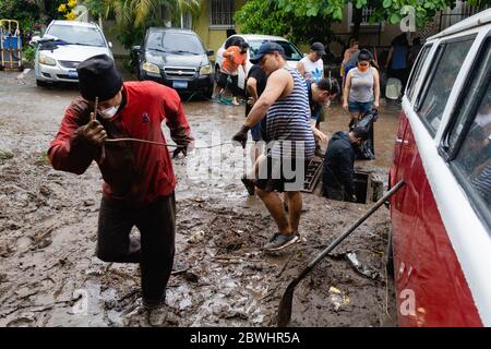 Mejicanos, El Salvador. 31. Mai 2020 - mehrere Nachbarn reinigen und entfernen den Schlamm und Trümmer durch den tropischen Sturm Amanda verlassen. Stockfoto