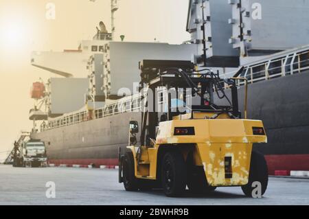 Großer Gabelstapel mit Stahlstange neben dem Schiff am Seehafen. Ladung, die vom Schiff entlädt Stockfoto