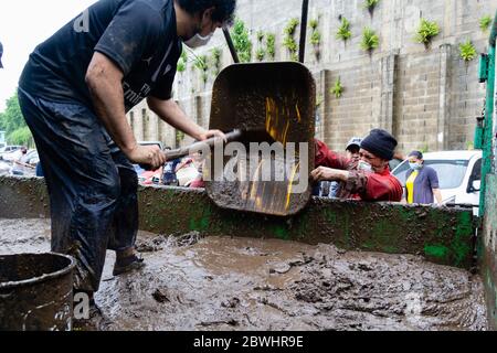 Mejicanos, El Salvador. 31. Mai 2020 - mehrere Nachbarn reinigen und entfernen den Schlamm und Trümmer durch den tropischen Sturm Amanda verlassen. Stockfoto