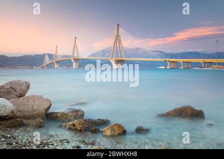 Urban Modern Bridge am Abend Sonnenuntergang mit rosa Wolken. Rion-Antirion-Brücke, Griechenland, Europa. Die Rion-Antirion-Brücke in Griechenland eine der w Stockfoto