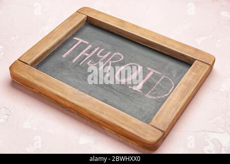 Brett mit Text SCHILDDRÜSE auf farbigen Hintergrund Stockfoto