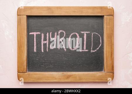 Brett mit Text SCHILDDRÜSE auf farbigen Hintergrund Stockfoto