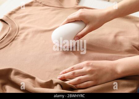 Frau, die zu Hause einen Stoffrasierer verwendet Stockfoto