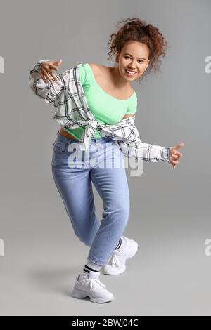 Afroamerikanische Hip-Hop-Tänzerin auf grauem Hintergrund Stockfoto