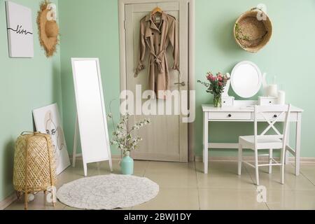 Interieur des Zimmers mit stilvollen Spiegeln und Frühlingsblumen Stockfoto