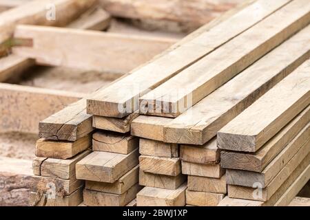 Holzstapel von natürlichen rauhen Holzbrettern auf der Baustelle. Material für den Bau. Stockfoto