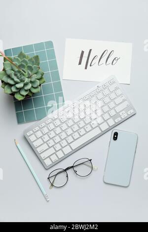 Computertastatur mit Notebook, Handy und Brille auf weißem Hintergrund Stockfoto