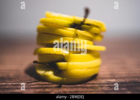 Gesundes pflanzliches Konzept für Lebensmittelzutaten, gelbe Äpfel in gestapelte Scheiben geschnitten Stockfoto
