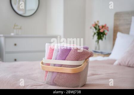 Korb mit sauberer Wäsche auf dem Bett Stockfoto