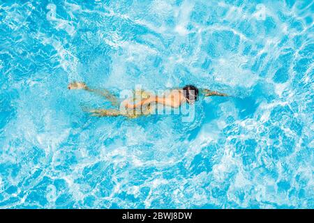 Ein Mann schwimmt einen Schmetterling in einem Pool auf dem Dach eines ...