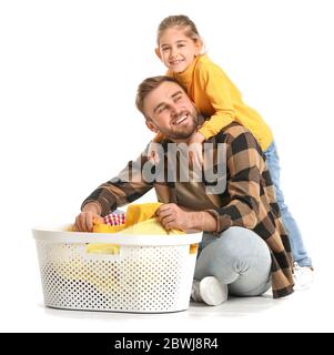 Glücklicher Vater und kleine Tochter mit Wäsche auf weißem Hintergrund Stockfoto