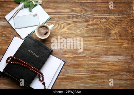 Heilige Bibel, Handy, Blumen und Kaffee auf Holzhintergrund Stockfoto