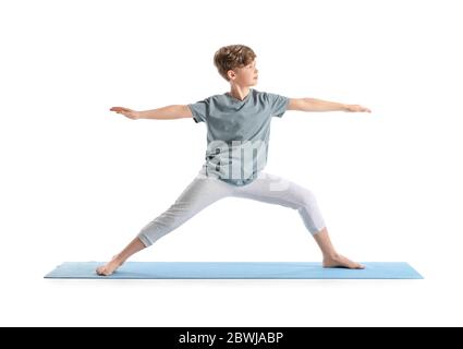 Niedlicher kleiner Junge, der Yoga auf weißem Hintergrund praktiziert Stockfoto