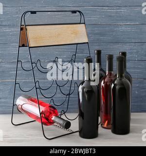 Halter mit Flaschen Wein auf Holzhintergrund Stockfoto