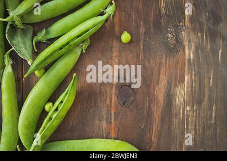 Frische grüne Erbsen auf Holztisch. Stockfoto