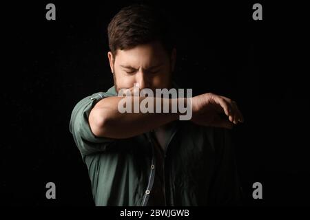 Hustender Mann auf dunklem Hintergrund. Konzept der Epidemie Stockfoto