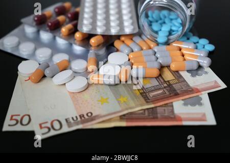 Pillen und Kapseln auf Euro-Rechnungen. Konzept der Gesundheitsversorgung, Pharmaindustrie, Arzneimittelpreise in der EU, Apotheke, Medizin und Wirtschaft Stockfoto