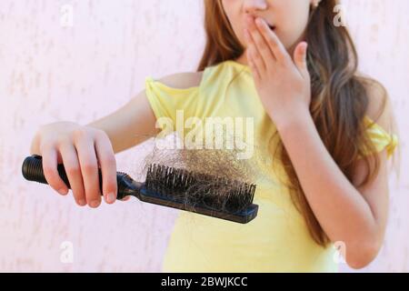 Mädchen ist schockiert über die Menge der Haare, die aus ist. Stockfoto