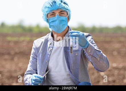 Wissenschaftler Untersuchung Proben von Boden in Feld Stockfoto