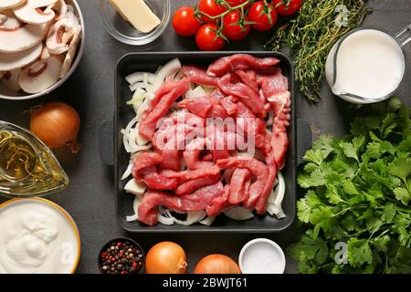 Zutaten für Rind Stroganoff mit Pilzen auf dunklem Hintergrund Stockfoto