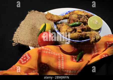 Gekochtes Hühnchen Curry in weißen Topf. Scharf und scharf Chicken Curry mit grüner Zitrone & Chili isoliert auf schwarzem Hintergrund. Stockfoto