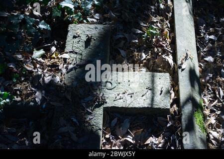 Beschädigte und zerstörte Grabsteine auf einem Friedhof in England, Großbritannien Stockfoto