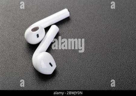 Moderne kabellose bluetooth-Kopfhörer auf dunkelschwarzem Hintergrund. Modernes Technologiekonzept Stockfoto