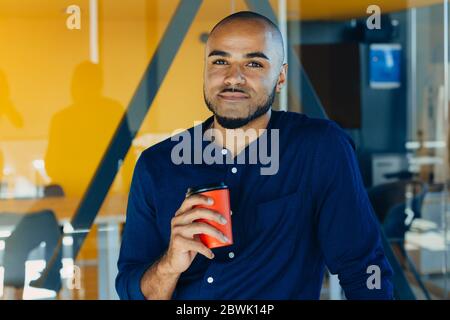 Happy african american Geschäftsmann mit Kaffee in den Händen in modernen Büro Stockfoto