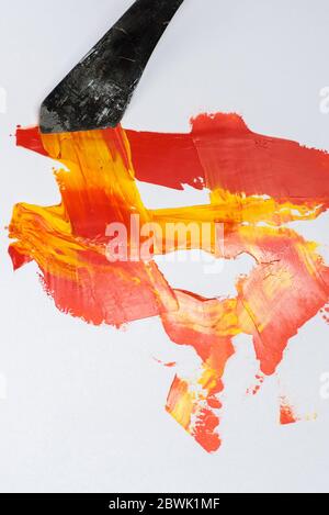 Pinsel und Spachtel Ölfarbe rote und gelbe Farben auf weißem Hintergrund Stockfoto