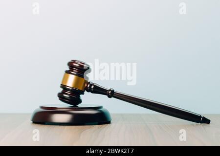 Symbol für Recht und Gerechtigkeit auf einem Holztisch und blauem Hintergrund im Büro des Rechtsanwalts Stockfoto