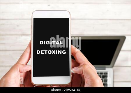 Halten Sie ein Mobiltelefon mit Text für die digitale Entgiftungstext auf dem Bildschirm. Digitales Detox-Konzept Stockfoto