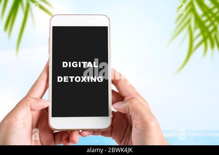 Hände, die ein Mobiltelefon mit Digital Detox Text halten. Digitales Detox-Konzept Stockfoto